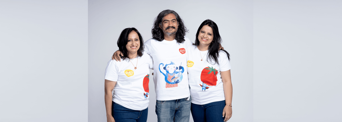Three people wearing white t-shirts with colorful graphics on a gray background